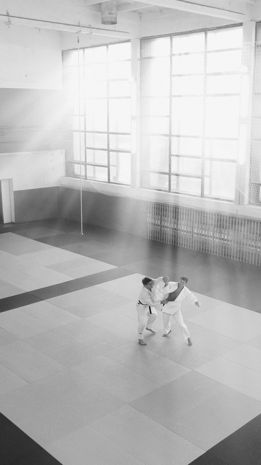 Zwei Judoka im Stand-Randori in einer Trainingshalle